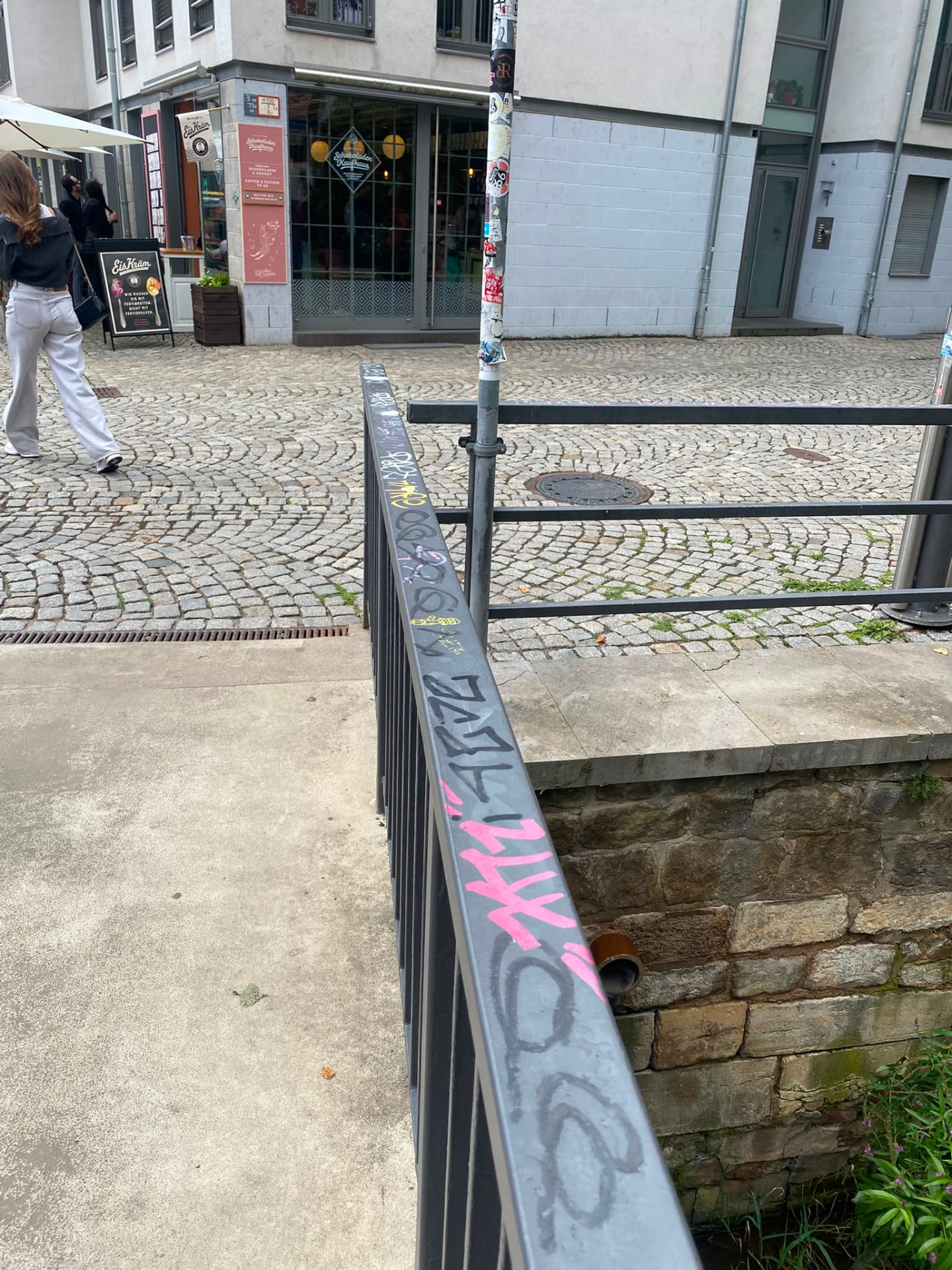 Metallgeländer mit Filzstift- und Sprühfarbe-Tags in einer Innenstadt