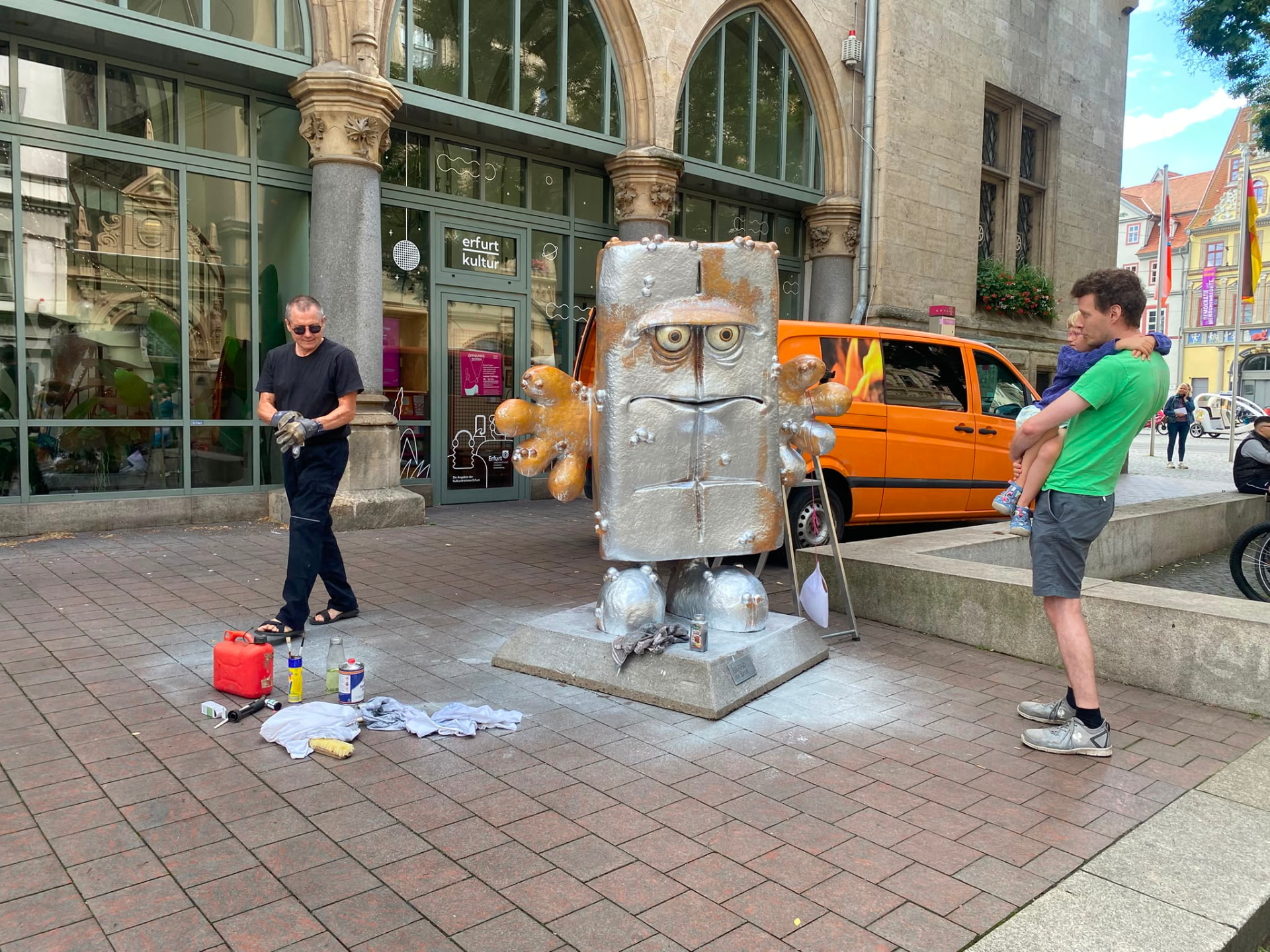 Bernd das Brot Statue in Erfurt mit Graffiti-Verschmutzung, ein Reinigungsfachkraft zieht Handschuhe an