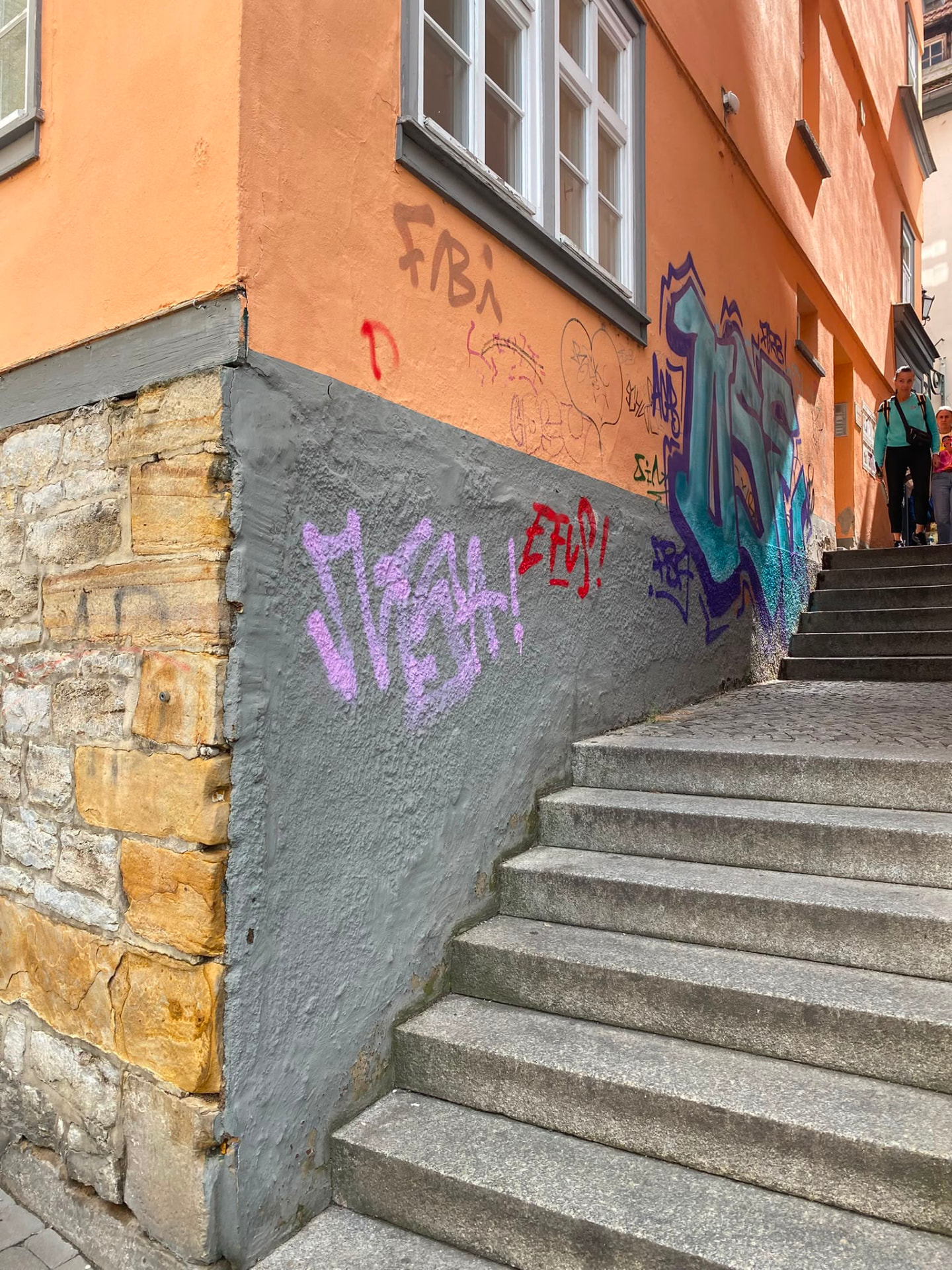 Treppenaufgang mit besprühter Stützmauer und farbigem Graffiti-Piece